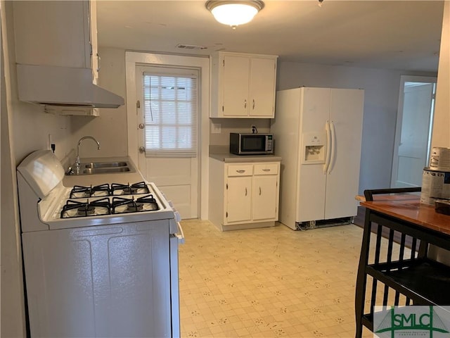 kitchen featuring visible vents, a sink, white appliances, white cabinets, and light floors