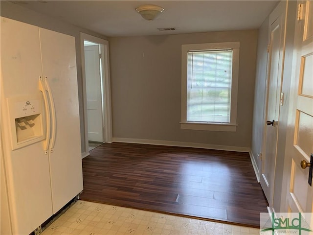 interior space featuring baseboards, visible vents, and light floors