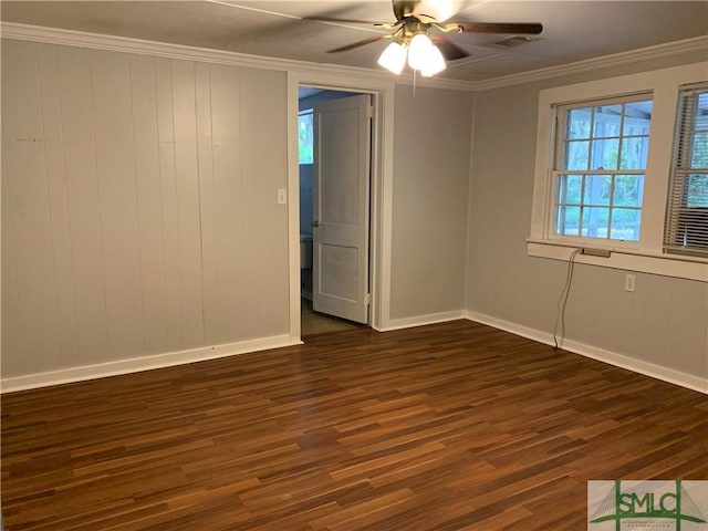 unfurnished room with visible vents, baseboards, dark wood finished floors, ceiling fan, and ornamental molding