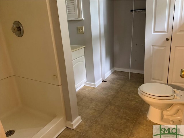 bathroom with tile patterned floors, toilet, baseboards, and a stall shower