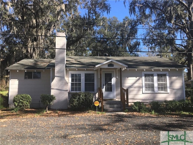 single story home featuring a chimney