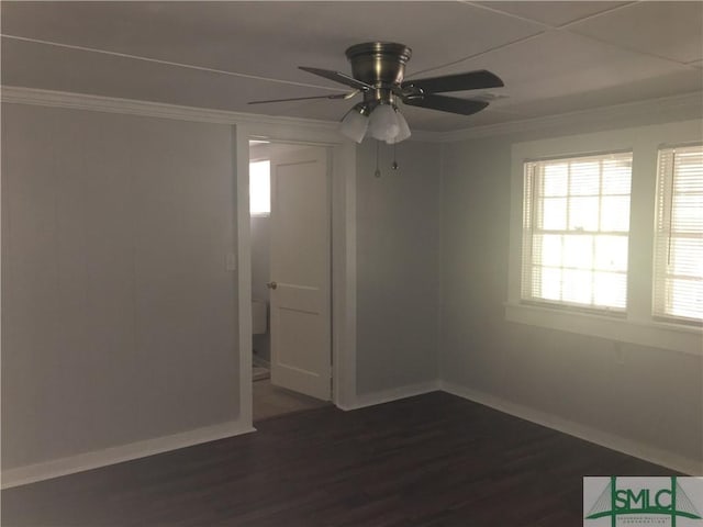 empty room with dark wood finished floors, a ceiling fan, baseboards, and ornamental molding