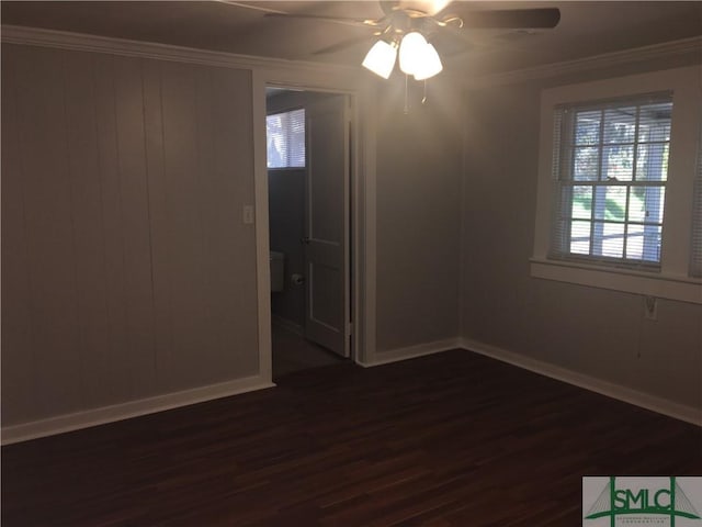 unfurnished room featuring dark wood finished floors, baseboards, a ceiling fan, and ornamental molding