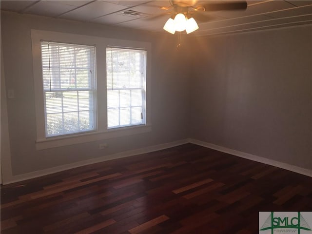 empty room with visible vents, baseboards, dark wood-style floors, and a ceiling fan