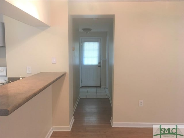 hall with wood finished floors and baseboards