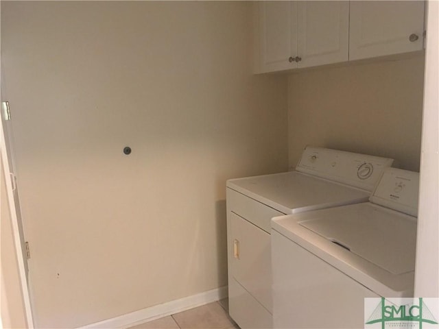 laundry area featuring baseboards, cabinet space, separate washer and dryer, and light tile patterned flooring