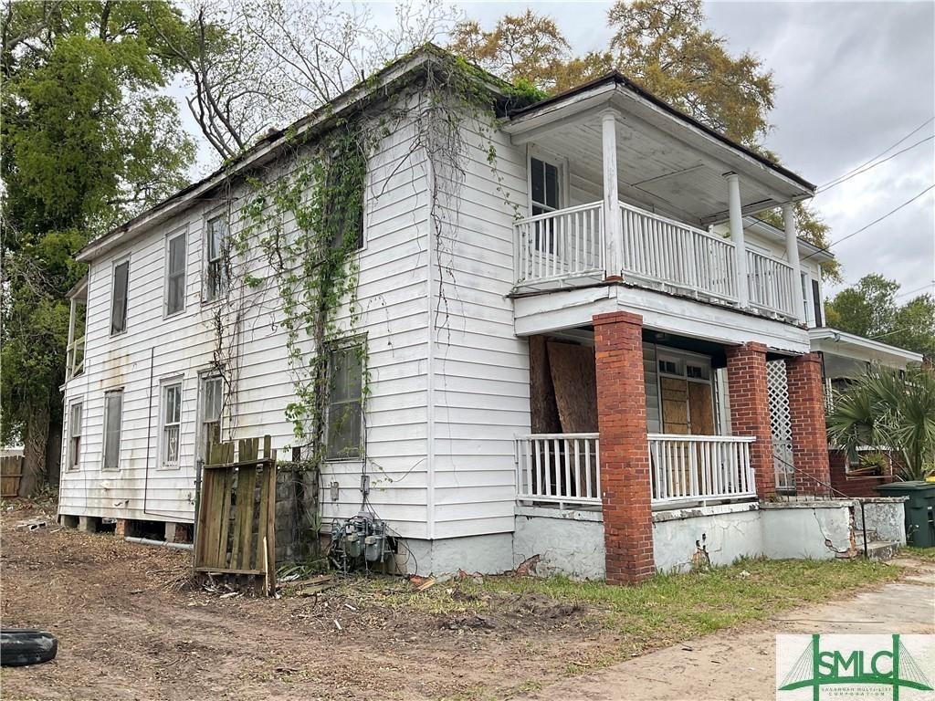 view of side of home with a balcony and covered porch