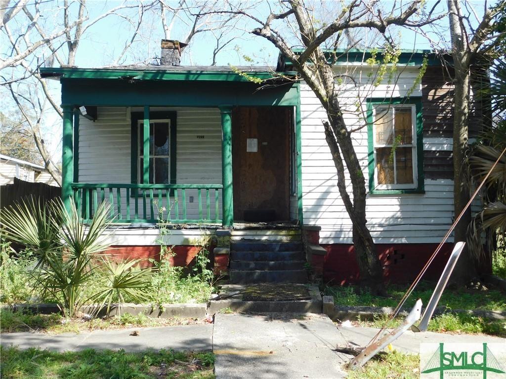 view of front facade featuring a porch and a chimney