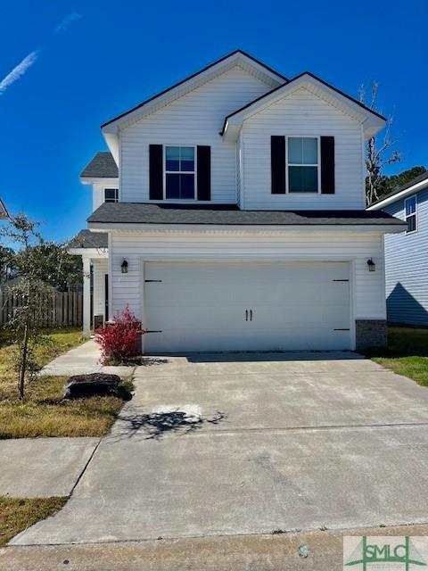 traditional-style home with concrete driveway, an attached garage, and fence