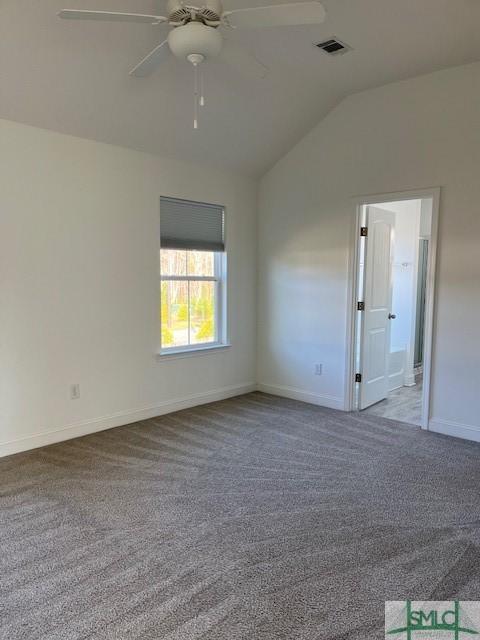 unfurnished room with a ceiling fan, baseboards, visible vents, carpet floors, and vaulted ceiling