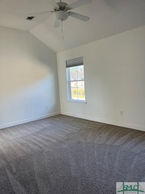 unfurnished room featuring visible vents, dark carpet, baseboards, and lofted ceiling