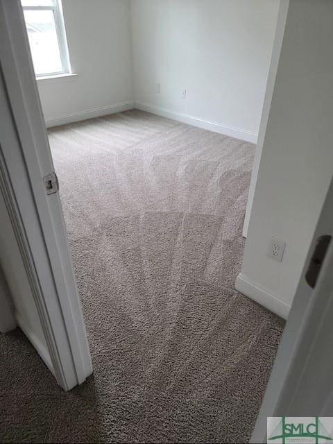 carpeted spare room featuring baseboards
