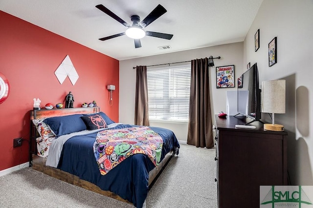 carpeted bedroom with visible vents, baseboards, and a ceiling fan