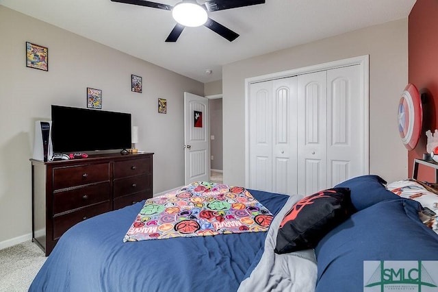 carpeted bedroom with a closet, baseboards, and ceiling fan