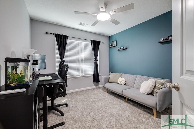 carpeted office with baseboards, visible vents, and ceiling fan