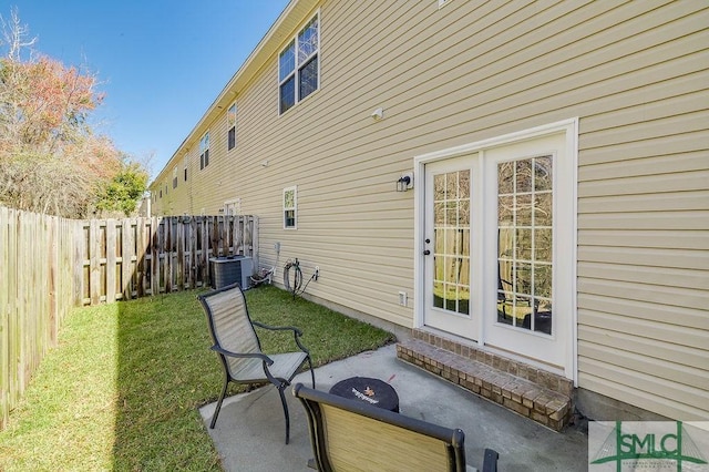 rear view of house with a patio, a lawn, central AC unit, and a fenced backyard