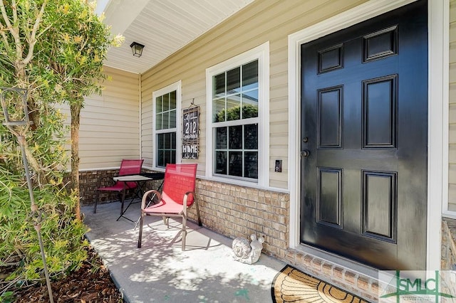 entrance to property featuring brick siding and a porch