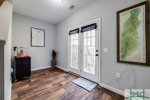 doorway to outside with visible vents, baseboards, and wood finished floors