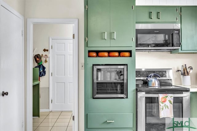 kitchen with light tile patterned floors, appliances with stainless steel finishes, and green cabinets