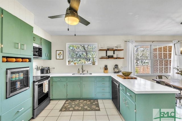 kitchen with a sink, open shelves, stainless steel appliances, a peninsula, and light countertops