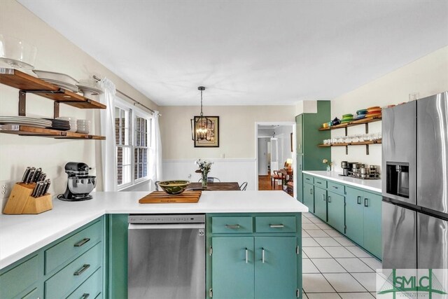 kitchen featuring open shelves, a peninsula, light countertops, and stainless steel appliances