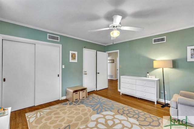 bedroom featuring visible vents, a closet, and wood finished floors