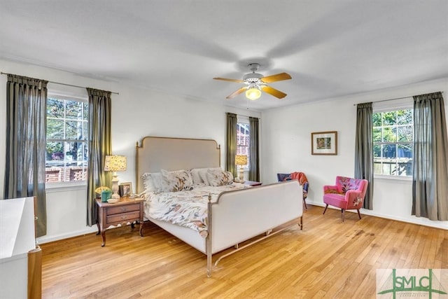 bedroom with ceiling fan, baseboards, and light wood-style flooring