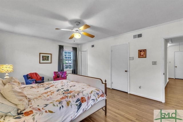 bedroom with visible vents, attic access, light wood-type flooring, and baseboards