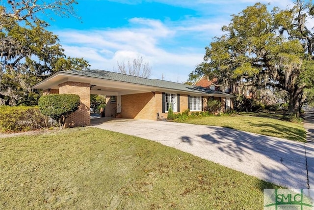 single story home featuring a carport, a front yard, brick siding, and driveway