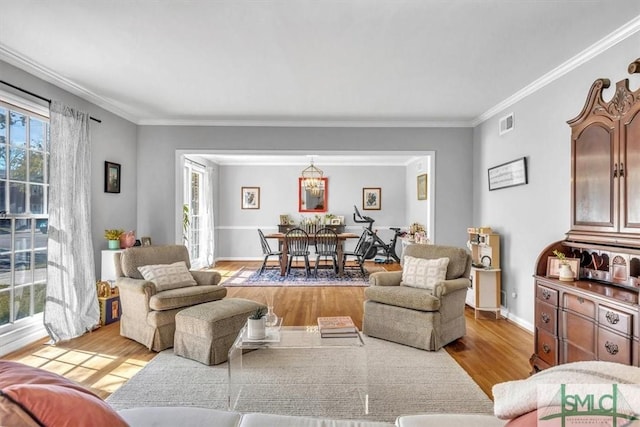 living area featuring ornamental molding, baseboards, and wood finished floors