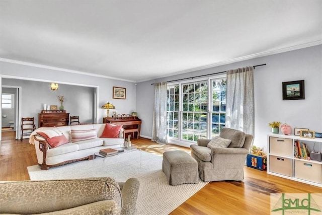 living room with wood finished floors and crown molding