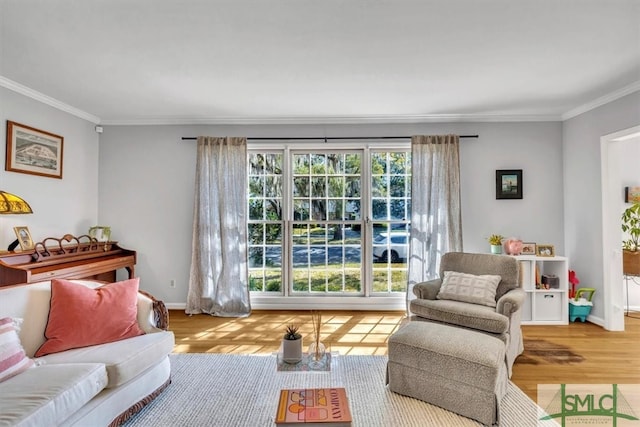 living area with a wealth of natural light, baseboards, wood finished floors, and crown molding