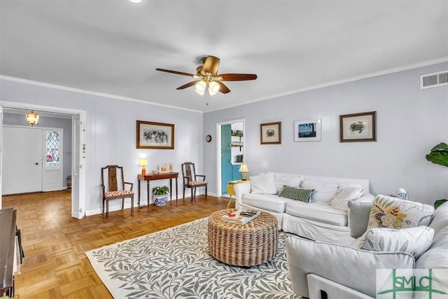 living area with crown molding, a ceiling fan, visible vents, and baseboards