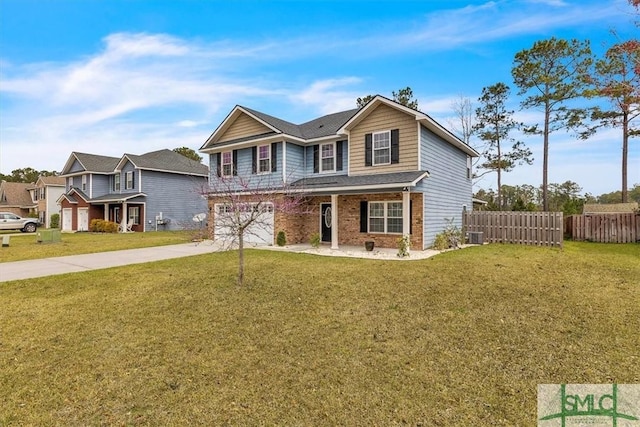 traditional home with fence, concrete driveway, a front yard, a garage, and brick siding