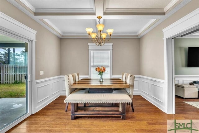 dining area with a notable chandelier, crown molding, plenty of natural light, and wood finished floors