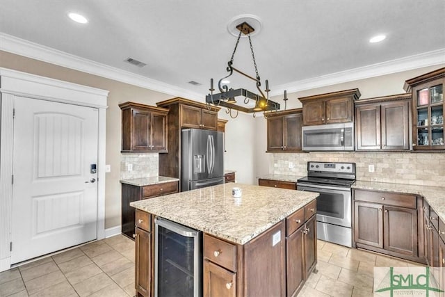 kitchen with wine cooler, a center island, stainless steel appliances, and crown molding