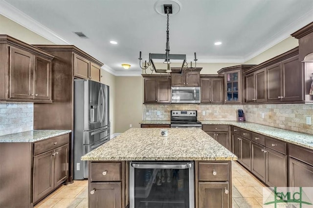 kitchen with visible vents, a center island, beverage cooler, ornamental molding, and appliances with stainless steel finishes