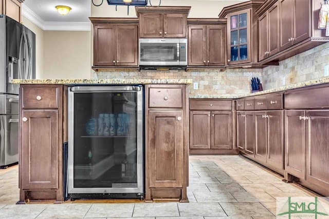 kitchen with backsplash, crown molding, light stone countertops, beverage cooler, and stainless steel appliances