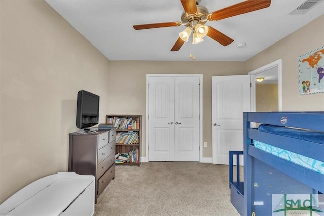 carpeted bedroom with a ceiling fan, visible vents, a closet, and baseboards