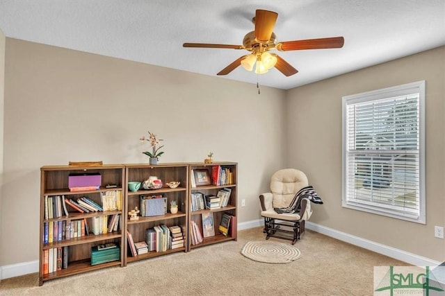 sitting room featuring baseboards, ceiling fan, and carpet flooring