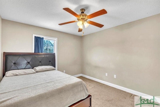 carpeted bedroom featuring baseboards, a textured ceiling, and ceiling fan