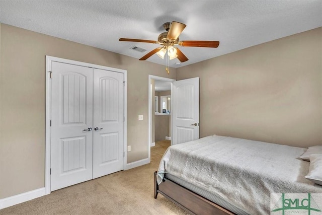 bedroom with baseboards, visible vents, a closet, and light carpet