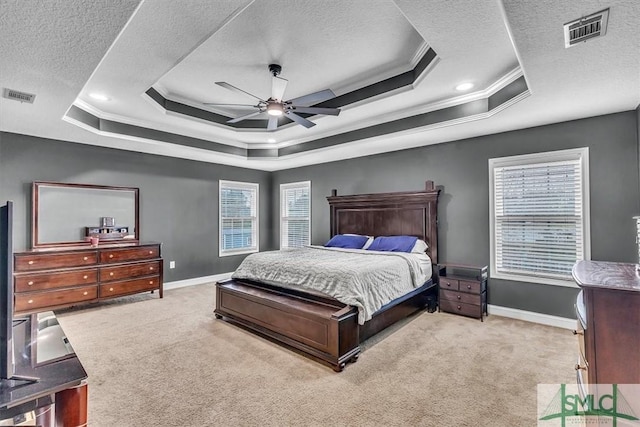 bedroom featuring a tray ceiling, visible vents, and carpet flooring