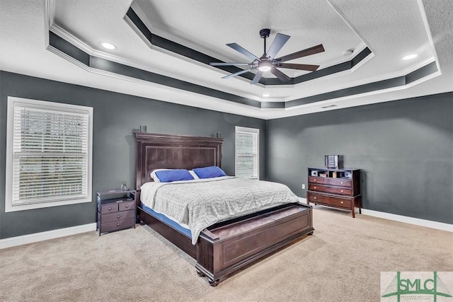 carpeted bedroom featuring a tray ceiling, crown molding, baseboards, and a textured ceiling