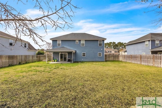 rear view of house featuring a yard, a patio area, and a fenced backyard