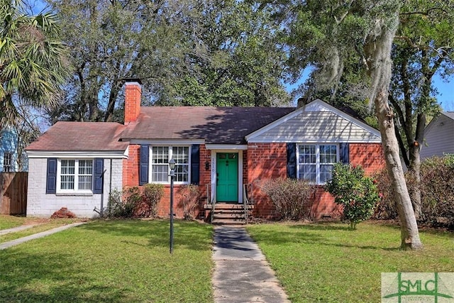 view of front facade with fence, a chimney, a front lawn, crawl space, and brick siding