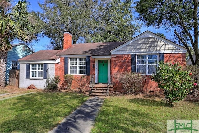 single story home with brick siding, a chimney, and a front yard