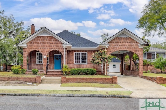 view of front of home featuring brick siding, a chimney, concrete driveway, and a shingled roof