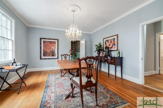 dining area featuring crown molding, light wood-style floors, and baseboards