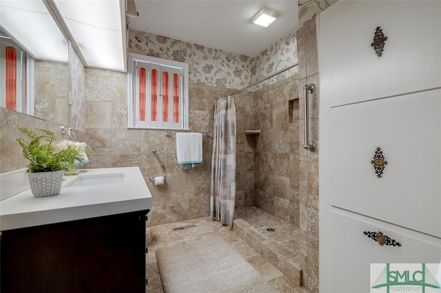 bathroom featuring tile walls, vanity, and a tile shower